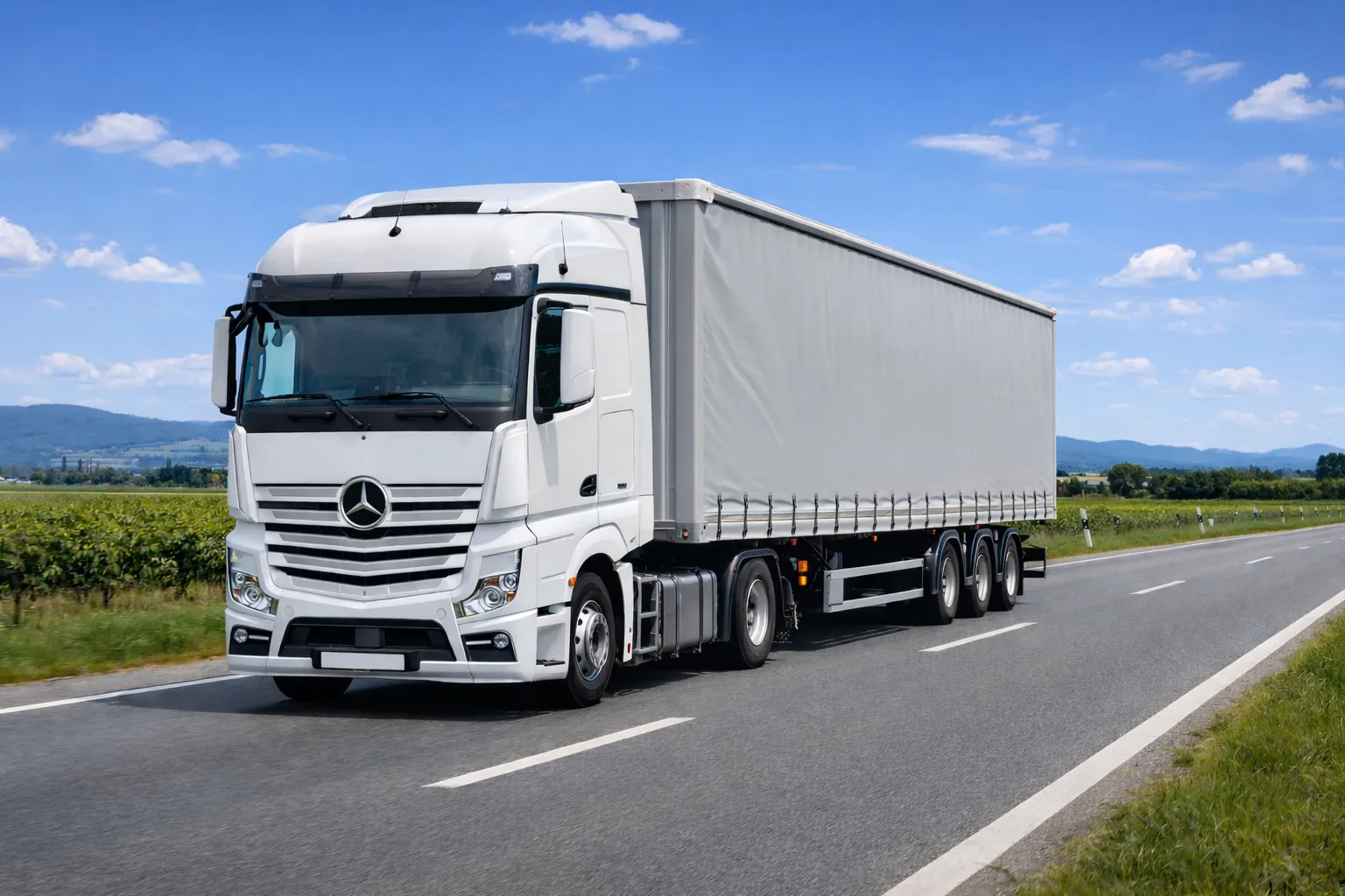 White articulated truck driving on a rural road