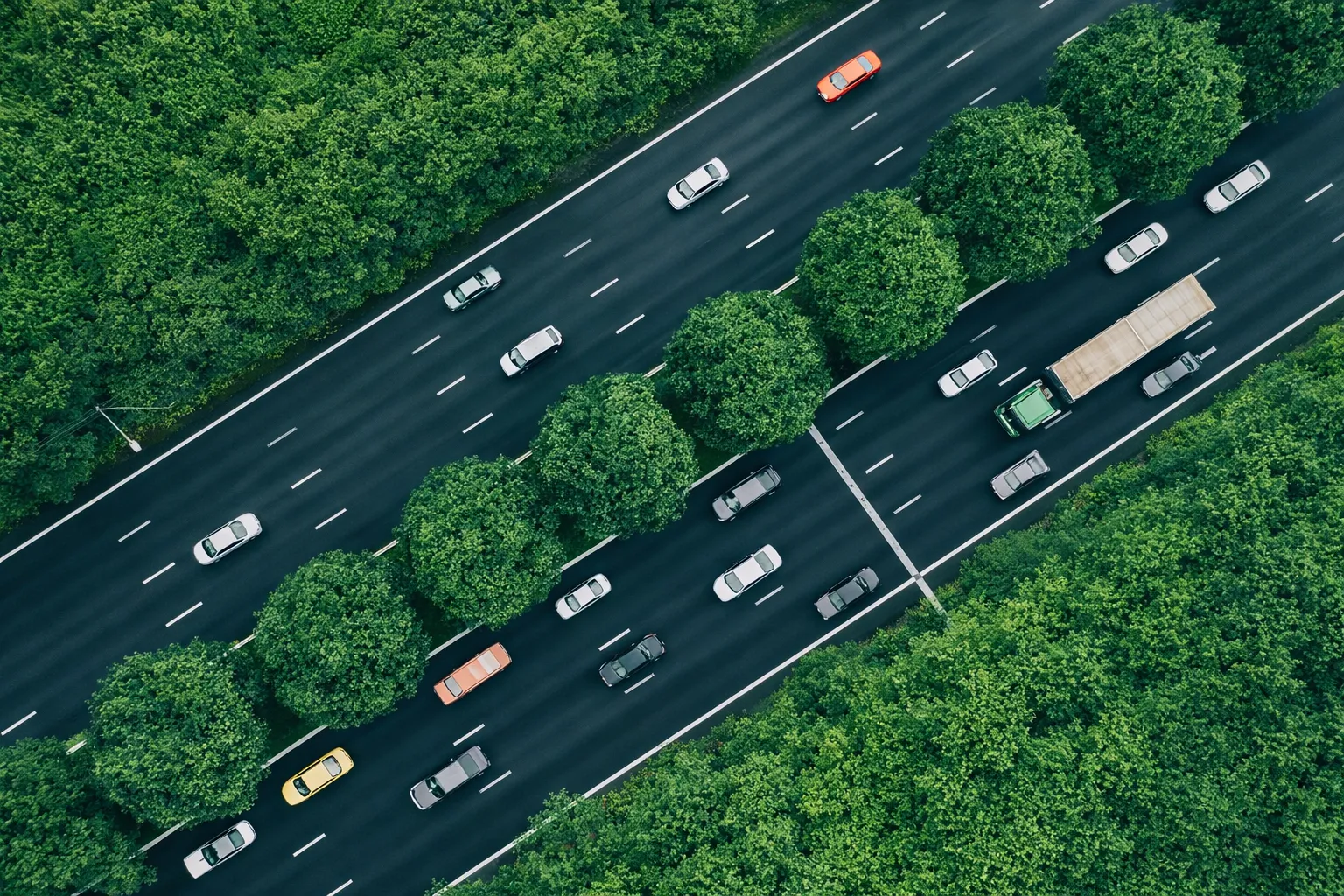Aerial view of mixed traffic on a tree-lined highway